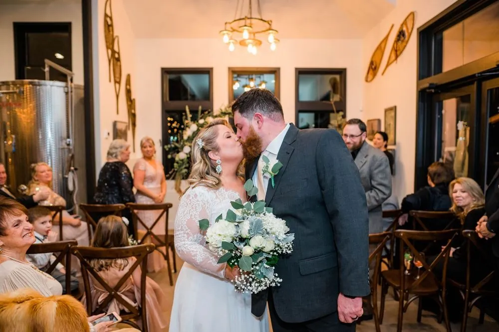 The couple shares a first kiss as seated guests look on