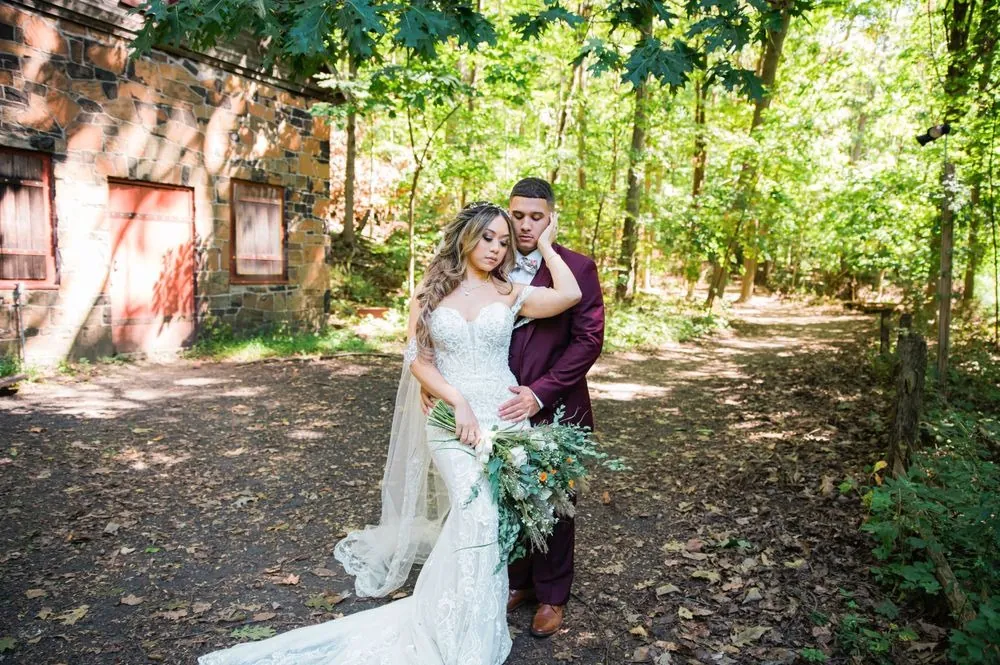 Tatiana leans back against Tyler on a sunlit wooded trail