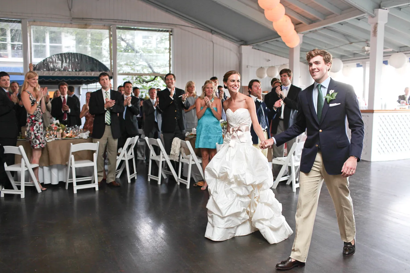 Trevor and Christina walk into the pavilion as guests stand and clap