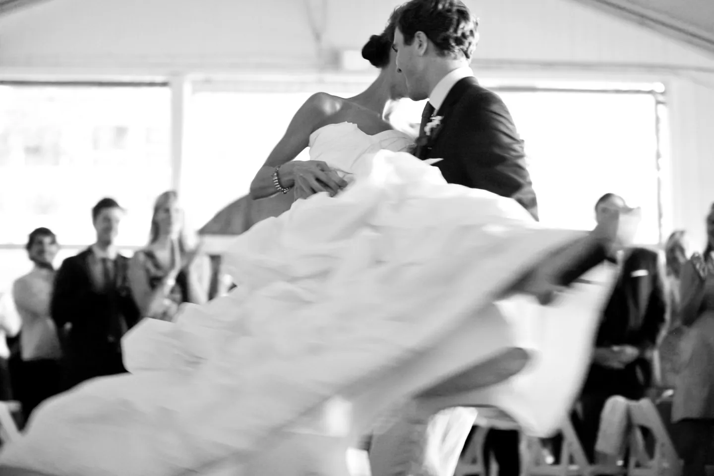 Black and white first dance, the groom dipping the bride as her skirt sweeps out