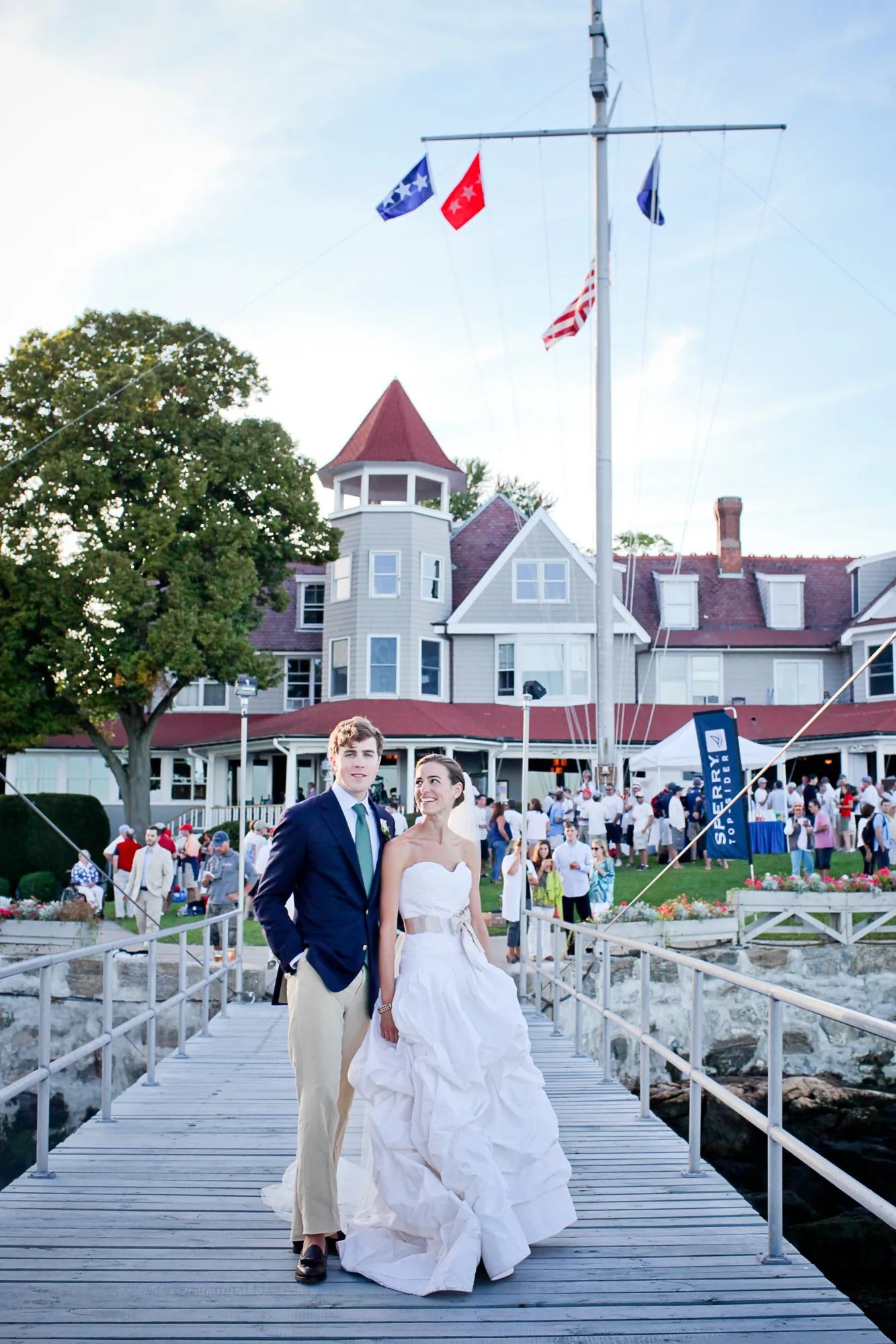 Trevor and Christina walk the long pier with the clubhouse and flagpole behind