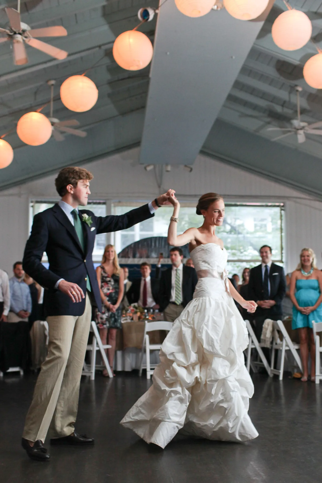 The couple dance under a line of paper lanterns in the open pavilion
