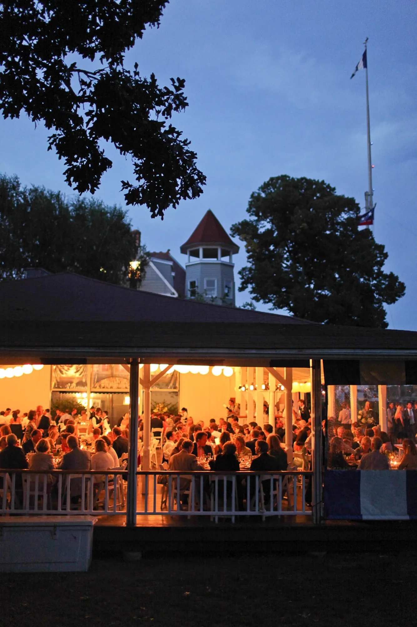 The clubhouse pavilion glows orange under a deep blue dusk sky