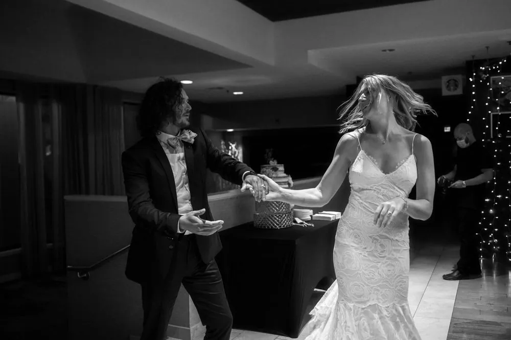 Black and white frame of the couple dancing apart, arms out