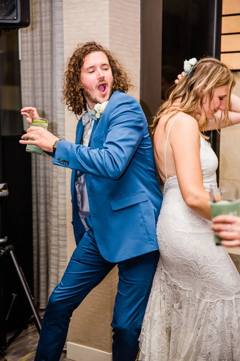 The groom dances with a grin beside the bride late in the evening