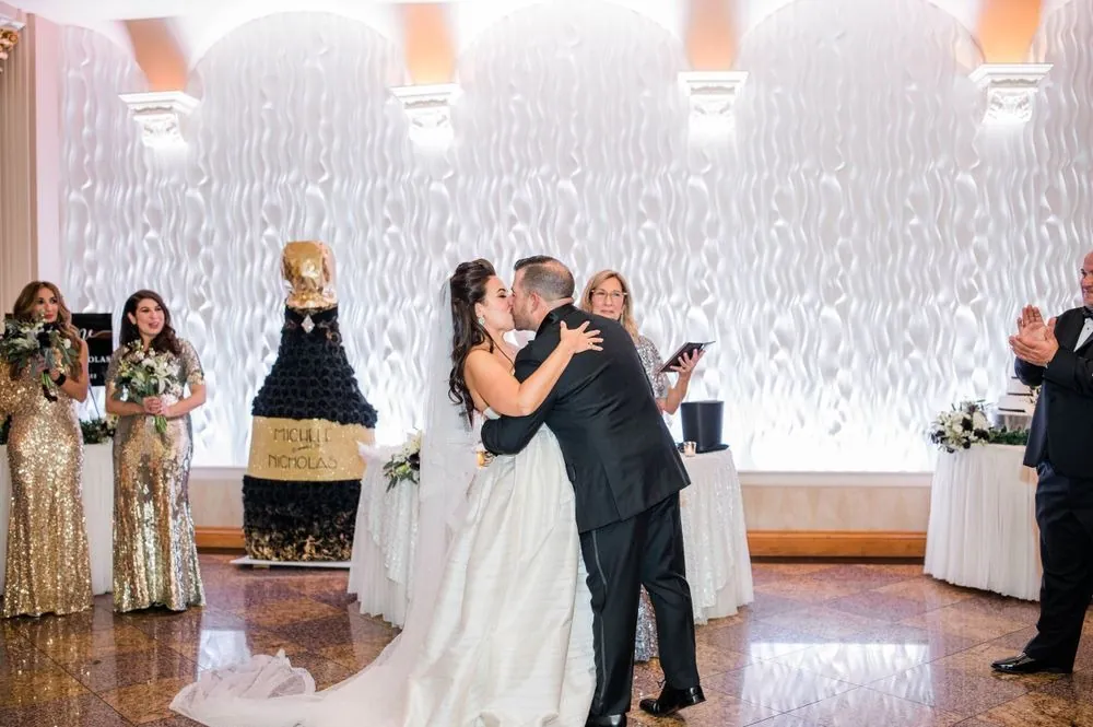 Michele and Nicholas slow dance in front of the sculpted white wall